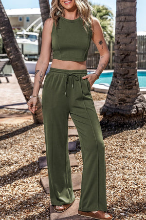 a woman wearing a crop top and wide legged pants