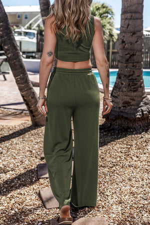 a woman in a cropped top and wide legged pants