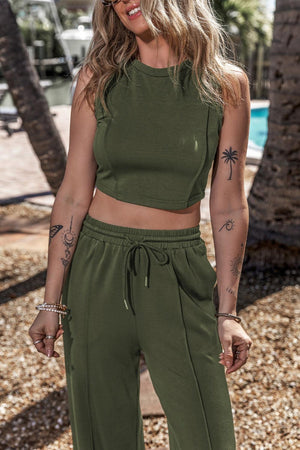 a woman wearing a crop top and pants