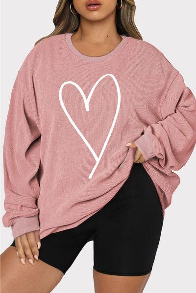 a woman wearing a pink sweater with a heart on it