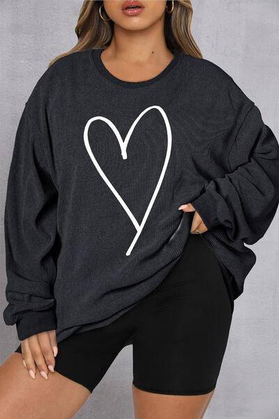 a woman wearing a black sweatshirt with a white heart on it