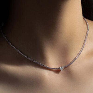 a close up of a woman's neck wearing a diamond necklace