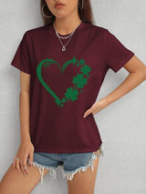 a woman wearing a t - shirt with a shamrock heart on it