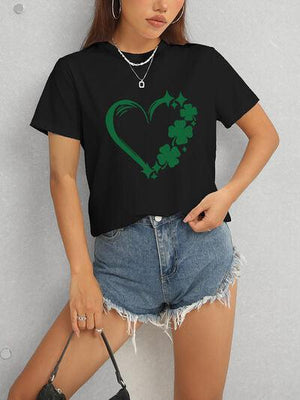 a woman wearing a black t - shirt with a shamrock heart on it