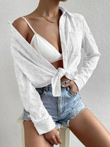 a woman wearing a white shirt and denim shorts