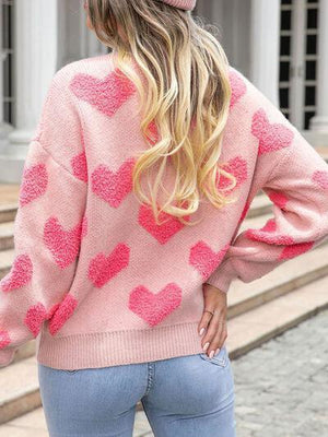 a woman wearing a pink sweater with hearts on it