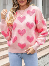 a woman wearing a pink sweater with hearts on it