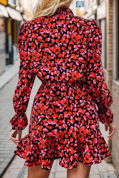 a woman walking down a street wearing a red and black dress