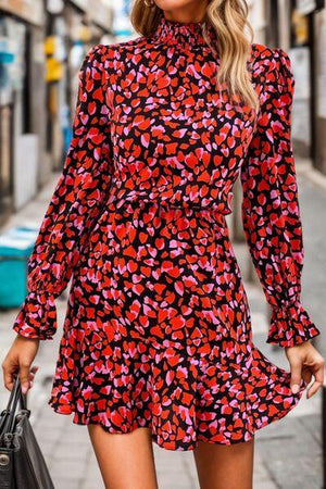 a woman wearing a red and black floral print dress