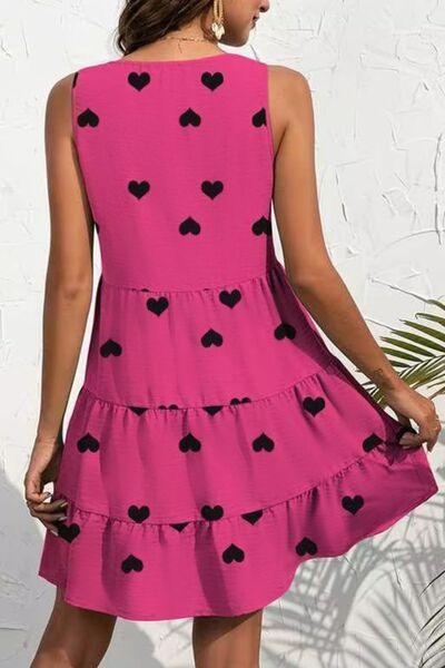 a woman wearing a pink dress with black hearts on it