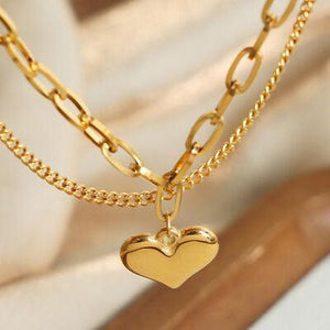 a gold necklace with a heart on it