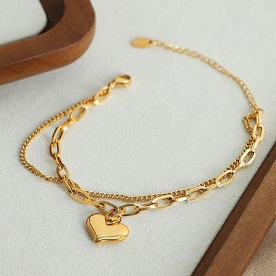 a gold bracelet with a heart charm