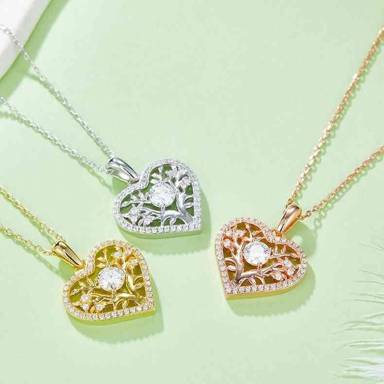 three heart shaped pendants on a green surface