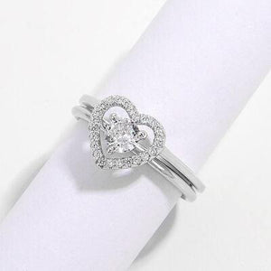 a heart shaped diamond ring sitting on top of a napkin