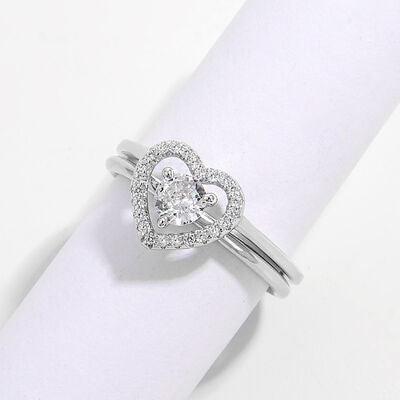 a heart shaped diamond ring sitting on top of a napkin