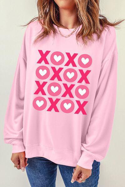 a woman wearing a pink sweatshirt with hearts on it