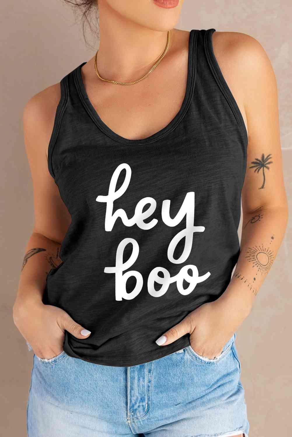 a woman wearing a black tank top that says hey boo