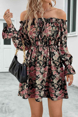 a woman wearing a black floral print dress