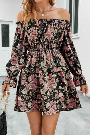 a woman wearing a black floral print dress