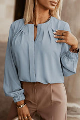 a woman wearing a blue blouse and tan pants