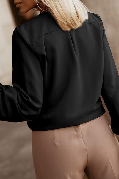 a woman wearing a black blouse and tan pants