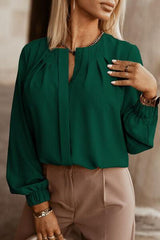 a woman wearing a green blouse and tan pants