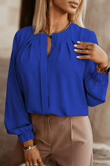 a woman wearing a blue blouse and tan pants