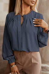 a woman wearing a blue blouse and tan pants