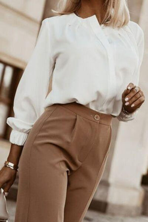 a woman in a white shirt and brown pants