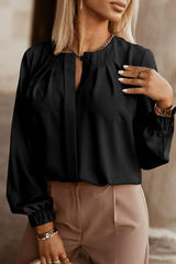 a woman wearing a black blouse and tan pants