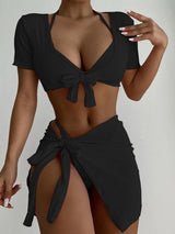 a woman in a black bikini top and skirt