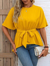 a woman wearing a yellow top and jeans