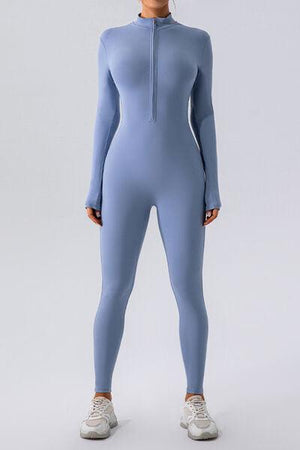 a woman in a blue bodysuit is posing for a picture