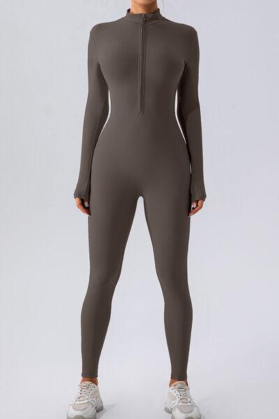 a woman in a grey bodysuit with zippers
