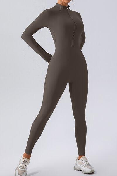 a woman in a grey bodysuit posing for a picture