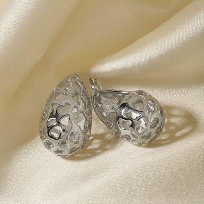 a pair of earrings sitting on top of a white cloth