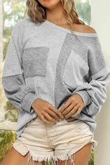 a woman wearing a grey sweater and white shorts