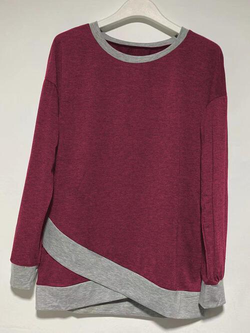a red and grey sweater hanging on a hanger
