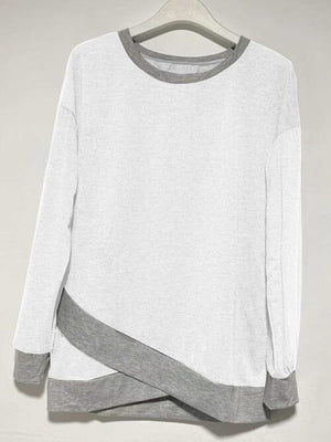 a white and grey sweater hanging on a hanger