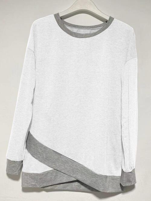 a white and grey sweater hanging on a hanger