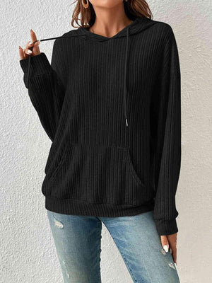 a woman wearing a black sweater and ripped jeans