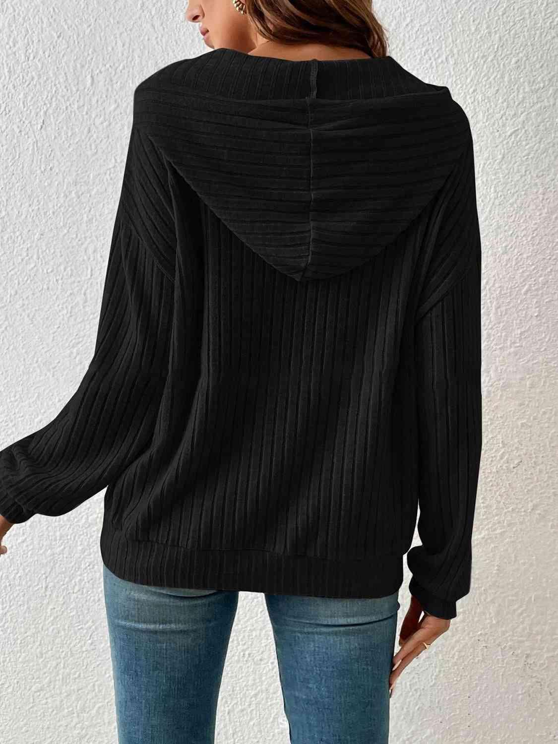 a woman wearing a black sweater and jeans