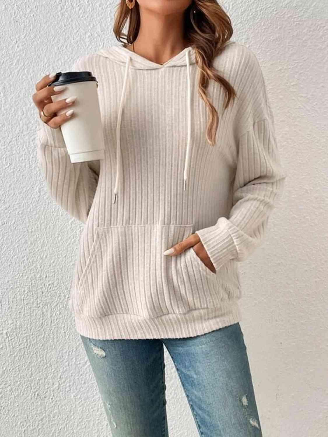 a woman wearing a white sweater and ripped jeans