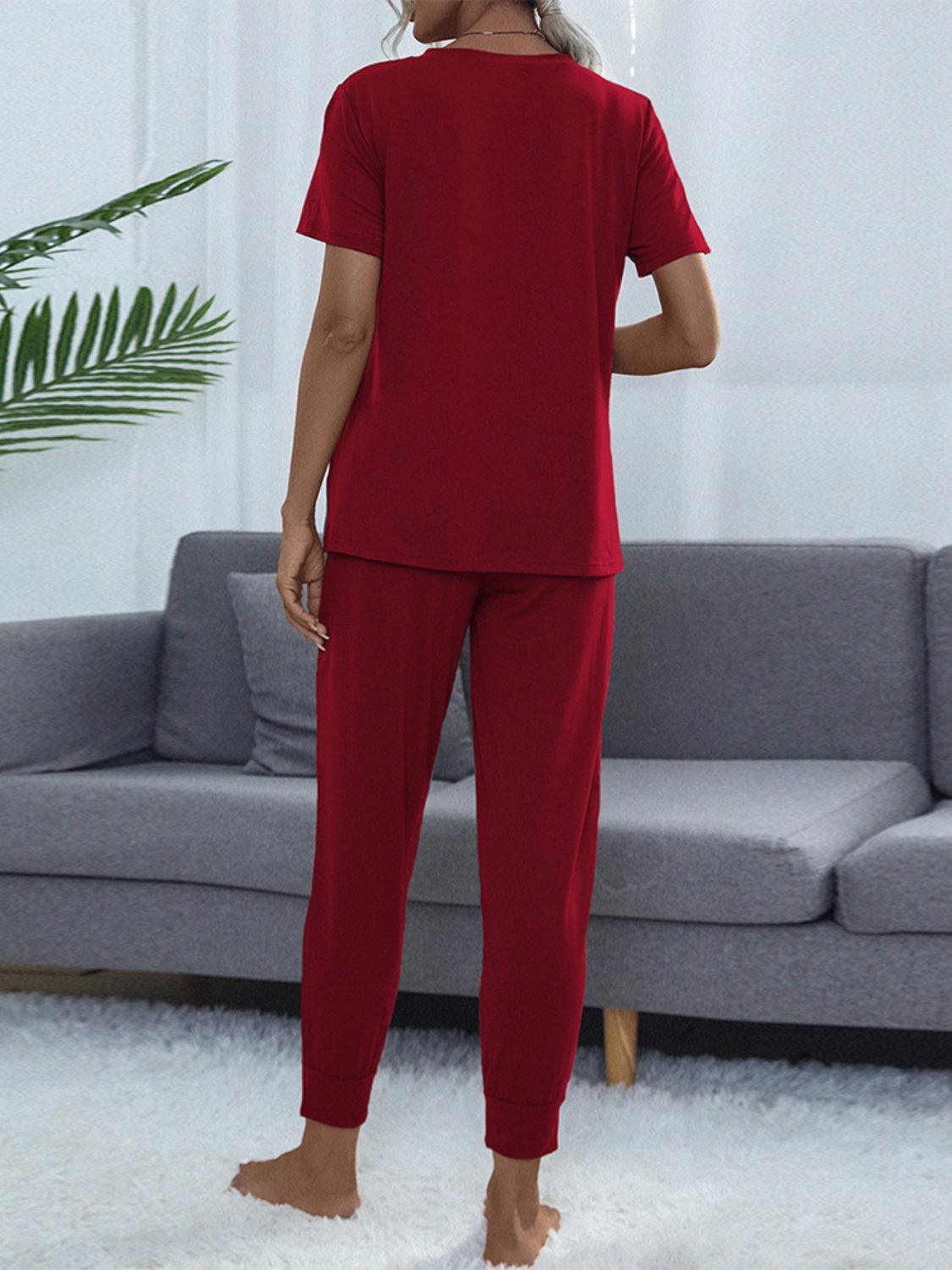 a woman standing in a living room wearing a red pajama set