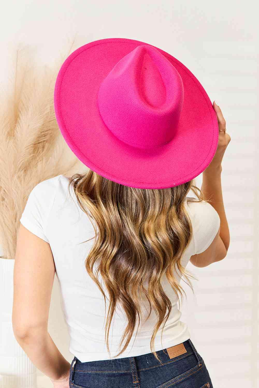 a woman with long hair wearing a pink hat