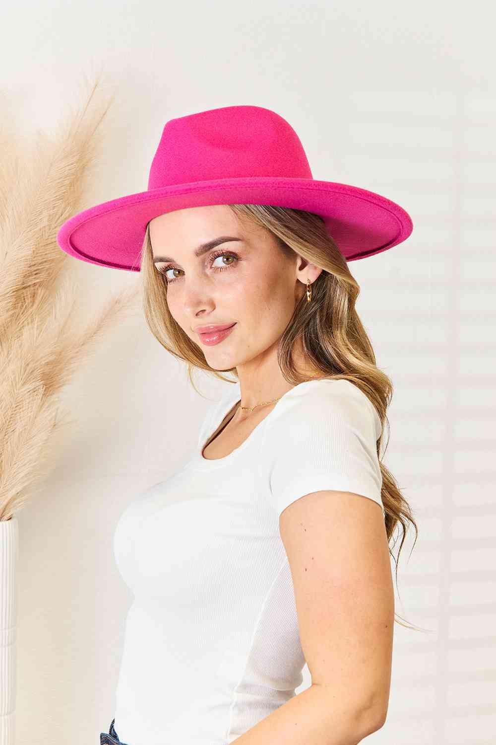 a woman in a white shirt and a pink hat