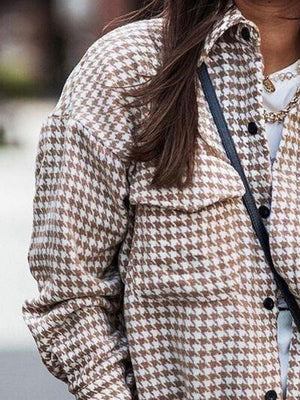 a woman is walking down the street with a cell phone in her hand