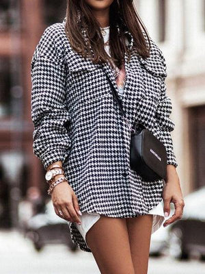 a woman is walking down the street wearing a hat