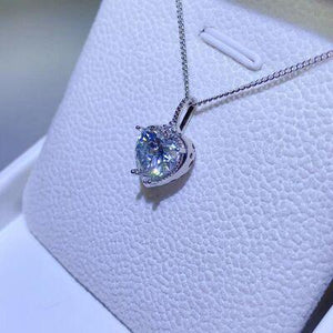 a necklace with a heart shaped diamond on it