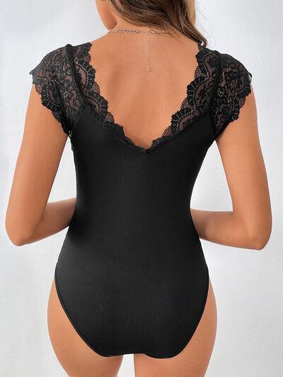 a woman wearing a black bodysuit with a lace back